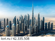 View of modern skyscrapers of Dubai city, UAE with burj khalifa, blue sky background. Amazing urban cityscape of new towers at blue sky. Construction and modern architecture concept. Copy text space. Стоковое AI-изображение, AI-художник Aleksandr Golubev / Фотобанк Лори