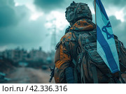 A guy in a soldier's uniform with an Israeli flag in his hand against a cloudy sky. Remembrance Day - Yom HaZikaron, Patriotic holiday, Israeli Independence Day - Yom Ha'atzmaut concept. Стоковое AI-изображение, AI-художник Ирина Михайличенко / Фотобанк Лори