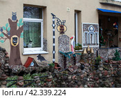 «Кошкин двор». Кошка в окне. Каменная крепость вдоль одной из стен дома. Гвардейск, Калининградская область (2023 год). Редакционное фото, фотограф Сергей Афанасьев / Фотобанк Лори