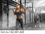 Caucasian woman training with barbell using squat rack in crossfit gym. Стоковое фото, фотограф Яков Филимонов / Фотобанк Лори