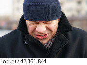 Мужчина чихает на улице города (2021 год). Стоковое фото, фотограф YuryKara / Фотобанк Лори