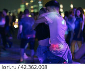 Moscow, Russia - August 20, 2019: Defocused photography of beautiful dancing people on the night party in the city street in  summer night.  Leisure, happiness and entertainment theme. Редакционное фото, фотограф YuryKara / Фотобанк Лори