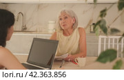 Elderly woman meeting financial advisor for investment at home. Стоковое видео, видеограф Яков Филимонов / Фотобанк Лори