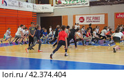 Sremska Mitrovica, Serbia 03.12.22: Children athletic competitions between school students. Strong boys and girls run, jump and play sports. Gym. Kids do warm-up, flexibility and agility exercises (2022 год). Редакционное видео, видеограф Юлия Петровская / Фотобанк Лори