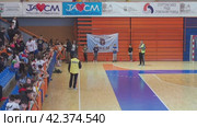 Sremska Mitrovica, Serbia 03.12.22: Children athletic competitions. School students. Gym. Boys do warm-up and get ready for cross-country. The coach gives instructions to the athletes. The stands. (2022 год). Редакционное видео, видеограф Юлия Петровская / Фотобанк Лори