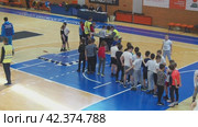 Sremska Mitrovica, Serbia 03.12.22: Children athletic competitions between school students. Boys and girls play sports. Gym. Kids stand in line for the long jump. Coach writes down the names in a log. (2022 год). Редакционное видео, видеограф Юлия Петровская / Фотобанк Лори
