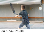 Moscow, Russia - July 26, 2019 Teenager ready to perform a trick at sportive push scooter on a city street. Редакционное фото, фотограф YuryKara / Фотобанк Лори