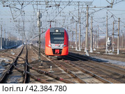 Электропоезд ЭС2Г-144 "Ласточка" в движении солнечным мартовским днем. Вид спереди. Октябрьская железная дорога (2024 год). Редакционное фото, фотограф Виктор Карасев / Фотобанк Лори