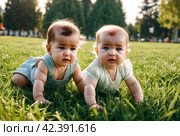 Crying unhappy baby girl crawling in green grass lawn summer urban park, sad depressed. Sorrowful kid creeping in city springtime season. Concept of childhood and baby health care. Copy text space. Стоковое AI-изображение, AI-художник Aleksandr Golubev / Фотобанк Лори