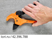 Ratcheting PVC pipe cutter, tube cutting tool for one-handed use, on gray background. Стоковое фото, фотограф Владимир Григорьев / Фотобанк Лори