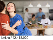 Hospitable hostess warmly greeting and kissing female friend. Стоковое фото, фотограф Яков Филимонов / Фотобанк Лори