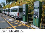 Eco-Friendly Transport: Minibuses at the Station Promoting an Eco-Friendly Lifestyle. Стоковое AI-изображение, AI-художник Юрий Поздников / Фотобанк Лори