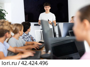 Young male teacher speaking to underage attendees of computer courses. Стоковое фото, фотограф Яков Филимонов / Фотобанк Лори