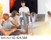 Young male teacher speaking to underage attendees of computer courses. Стоковое фото, фотограф Яков Филимонов / Фотобанк Лори