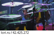 A professional drum kit captured from an angle showcasing three tom-toms with worn-out batter-heads and two cymbals. The presence of multiple microphones indicates it's used for performances. Стоковое фото, фотограф Воловодов Владимир / Фотобанк Лори