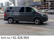 Fast moving Volkswagen Transporter T6 on the city road. Gray van rides on street. Commercial auto in fast motion with blurred background. speeding in the city concept (2021 год). Редакционное фото, фотограф Константин Григорьев / Фотобанк Лори