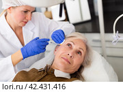Cosmetologist doing botulotoxin injections for senior woman. Стоковое фото, фотограф Яков Филимонов / Фотобанк Лори