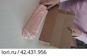 A woman reviews a purchased umbrella. He takes an umbrella out of the box. Vertical video. Стоковое видео, видеограф Vadzim Yakubovich / Фотобанк Лори