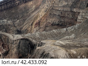 Close-up view of the rocks on the rim and inner slope of the volcanic crater. Majestic mountain landscape. Layers of rocks in the crater of a volcano. Rough stone texture. Great natural background. Стоковое фото, фотограф Андрей Степанов / Фотобанк Лори