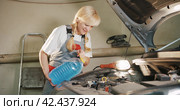 Автосервис. Attractive female mechanic carries out engine repairs in garage workshop. Стоковое видео, видеограф EStarodubov / Фотобанк Лори