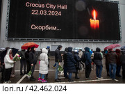 Люди стоят в очереди к стихийному мемориалу в память о погибших при теракте у здания концертного зала "Крокус сити холл", Московская область, Россия (2024 год). Редакционное фото, фотограф Николай Винокуров / Фотобанк Лори
