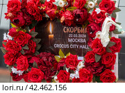 Люди несут цветы к стихийному мемориалу в память о погибших при теракте у здания концертного зала "Крокус сити холл", Московская область, Россия (2024 год). Редакционное фото, фотограф Николай Винокуров / Фотобанк Лори