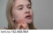 Fashion model descent applies cream foundation to face using makeup brush to alter natural skin tone. Стоковое видео, видеограф А. А. Пирагис / Фотобанк Лори
