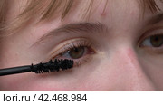 Woman is shown in an extreme close-up applying mascara to her brown eyes with the tip of brush to prevent clumping. Mascara may enhance and define appearance of eyes. Extreme close-up view process. Стоковое видео, видеограф А. А. Пирагис / Фотобанк Лори