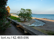 Тротуар у моря, цветут магнолии, пляж с редкими отдыхающими, в море впадает река Псырдзха. Новый Афон, Абхазия. Стоковое фото, фотограф Александр Пеньков / Фотобанк Лори