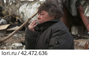 Бомж, бездомная женщина бродяга. Portrait homeless woman vagabond in a temporary place smoking a cigarette. Стоковое видео, видеограф EStarodubov / Фотобанк Лори