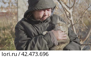 Бомж, бездомная женщина бродяга. Portrait of a homeless middle aged woman vagabond caressing a wandering cat. Стоковое видео, видеограф EStarodubov / Фотобанк Лори