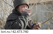 Бомж, бездомная женщина бродяга. Homeless unkempt woman in a temporary place drinks vodka, biting cheap food. Стоковое видео, видеограф EStarodubov / Фотобанк Лори