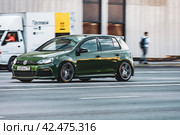 Green Volkswagen Golf 7 car moving on the street. VW Golf R is driving along city expressway. Редакционное фото, фотограф Константин Григорьев / Фотобанк Лори