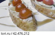 Sandwiches with cottage cheese and cucumber slices, cherry tomatoes on a white farm baguette on a wooden table. Close-up shooting. Стоковое видео, видеограф Ярославский Максим / Фотобанк Лори