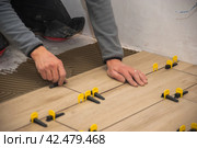 The process of laying floor tiles on the SVP Base, Tile Leveling System. Стоковое фото, фотограф Evgenii Predibailo / Фотобанк Лори