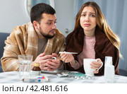 Woman and man wrapped in plaids having symptoms of cold at home. Стоковое фото, фотограф Яков Филимонов / Фотобанк Лори