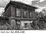 Кирпичная кладка старого здания. Кирпичный фон. Штукатурка отслаивается от кирпича на старом доме. Полуразрушенный дом, построенный в 19 веке. Второй деревянный этаж старого дома покрыт железом. Темный старый дом (2022 год). Стоковое фото, фотограф Эдуард Белкин / Фотобанк Лори