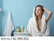 Woman smelling fabric softener in bathroom after wash. Generate Ai. Стоковое AI-изображение, AI-художник Иван Рябоконь / Фотобанк Лори