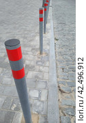 Ограничительные столбики на проезжей части дороги. Restrictive posts between the pedestrian sidewalk and the road. Стоковое фото, фотограф Татьяна Д / Фотобанк Лори
