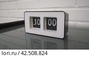 Перекидной циферблат часов будильника. Монтаж двух планов. Flip clock mechanism. 10:00 PM. Flip clock watch face. White brick wall in the background. Slow motion 240 fps. Стоковое видео, видеограф EStarodubov / Фотобанк Лори