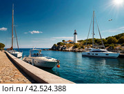 Sea panorama of moored yachts at Cape with lighthouse. Anchorage of ships at anchor. Marine life underwater in blue ocean. Observation animal world. Scuba diving adventure in Red sea, coast Africa. Стоковое AI-изображение, AI-художник Aleksandr Golubev / Фотобанк Лори