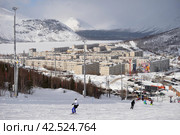Kirovsk, Murmansk region, Russia, March 10, 2024: View of Bolshoi Vudyavr Lake and Kirovsk, surrounded by Khibiny Mountains, from southern slope of Bolshoi Vudyavr ski complex. Редакционное фото, фотограф Алексей Антипов / Фотобанк Лори