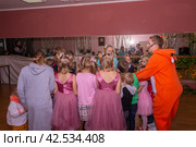 Аниматор играет с детьми из многодетных семей на праздничном мероприятии, организованном благотворительной организацией. The animator plays with children from large families at a festive event organized by a charity organization. (2021 год) Редакционное фото, фотограф Мария / Фотобанк Лори