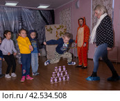 Аниматор играет с детьми из многодетных семей на праздничном мероприятии, организованном благотворительной организацией. The animator plays with children from large families at a festive event organized by a charity organization. (2021 год) Редакционное фото, фотограф Мария / Фотобанк Лори