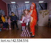 Аниматор играет с детьми из многодетных семей на праздничном мероприятии, организованном благотворительной организацией. The animator plays with children from large families at a festive event organized by a charity organization. (2021 год) Редакционное фото, фотограф Мария / Фотобанк Лори