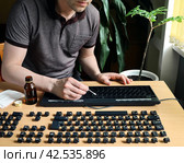 Man stays at home and thorough cleans the disassembled keyboard. Стоковое фото, фотограф Vladimir Vikhrov / Фотобанк Лори