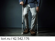 Resilient Man injured leg using crutches. Generate Ai. Стоковое AI-изображение, AI-художник Иван Рябоконь / Фотобанк Лори
