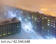 Город Норильск, Красноярский край, Сибирь, Россия. Вид сверху на ночной город. Холодная зимняя погода. Снегопад и морозный туман. Поздний вечер. Большой российский город в Арктике. Стоковое фото, фотограф Андрей Степанов / Фотобанк Лори