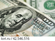 Close up of one hundred dollar bill with focus on Benjamin Franklins face. Стоковое AI-изображение, AI-художник Юрий Поздников / Фотобанк Лори