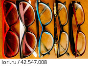 Set of various sunglasses in a row on table. grandma eyeglasses for everyday. Стоковое фото, фотограф Константин Григорьев / Фотобанк Лори